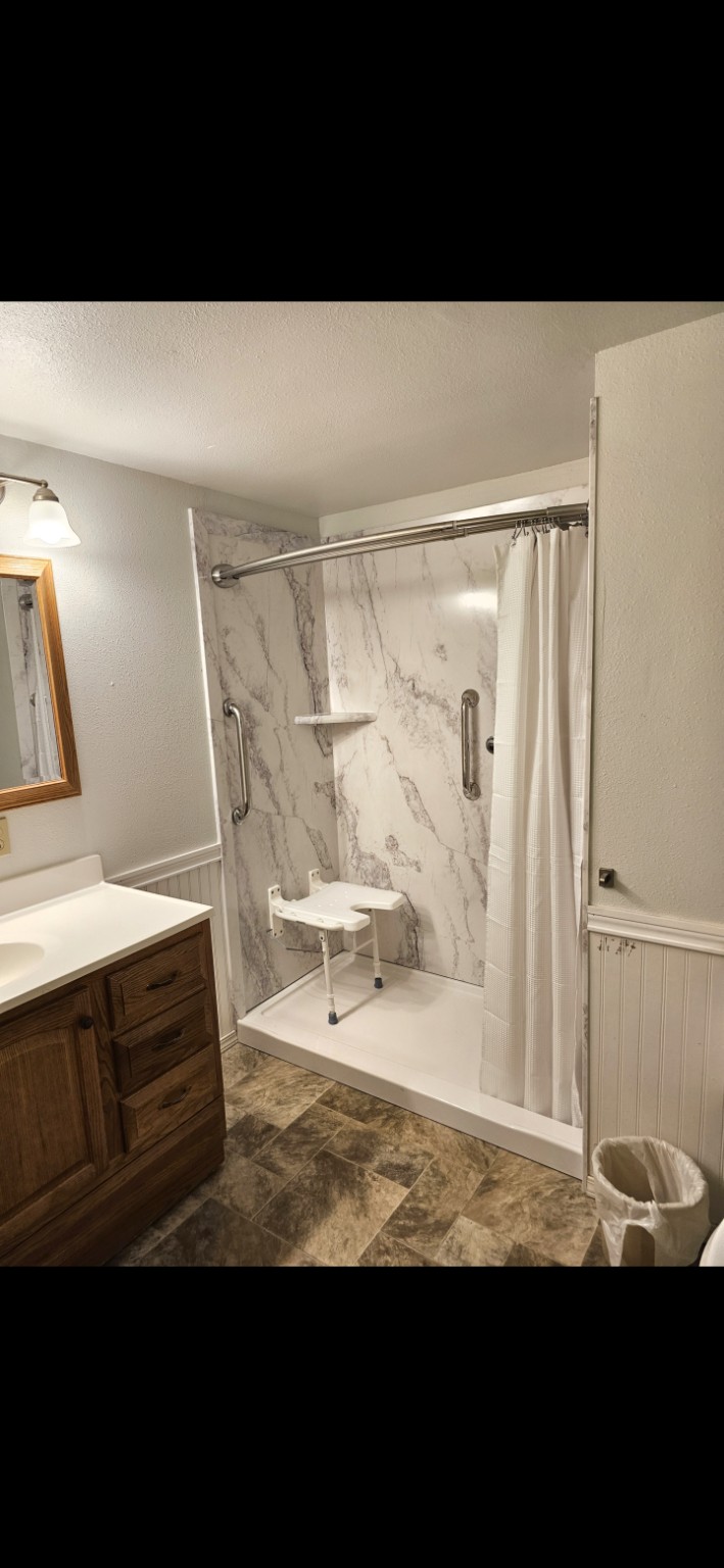 Finished FlexStone walk-in shower with seat and grab bars
