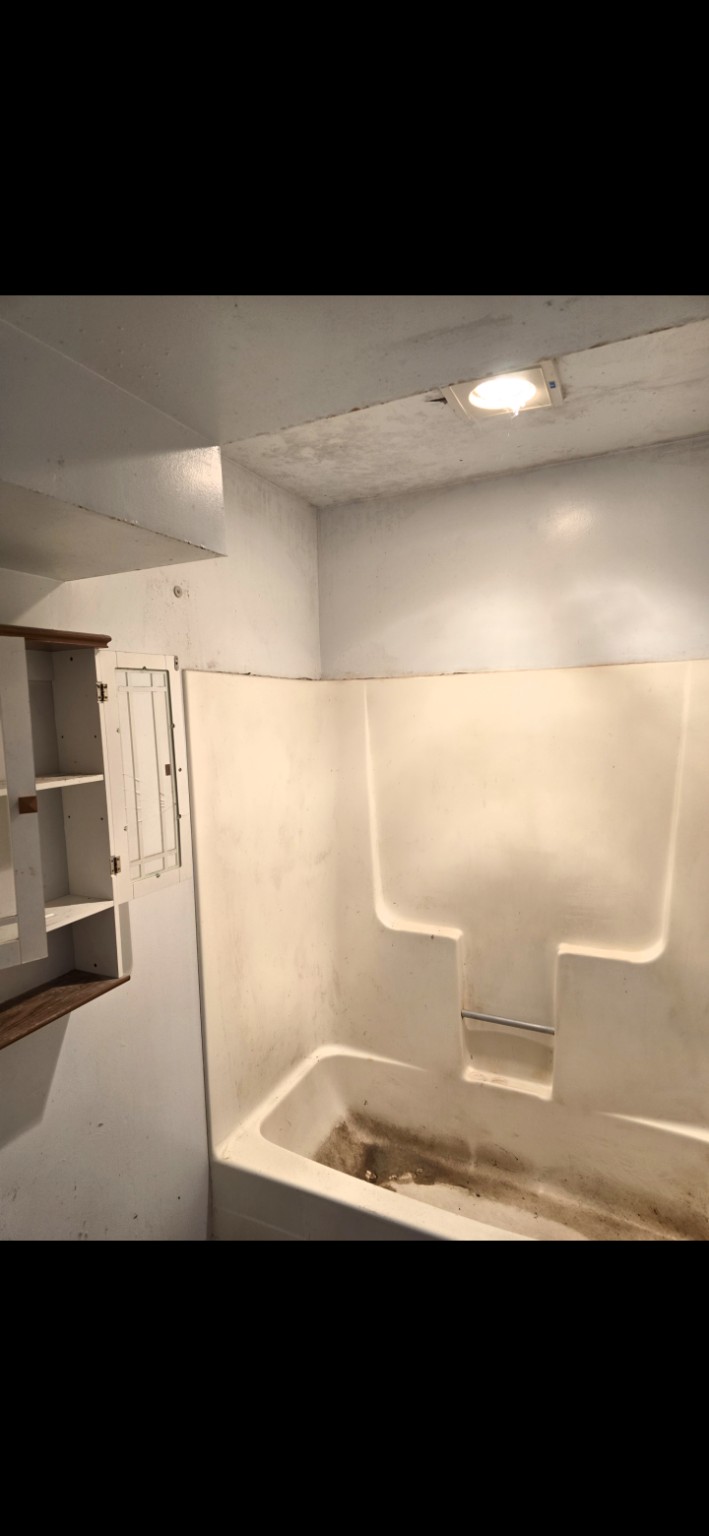 Old worn fiberglass tub and shower ready for removal